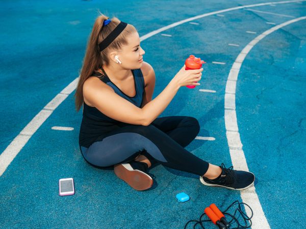 woman-sitting-playground-with-bottle-water-min